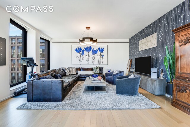 505 W 19th St Unit 7W, New York City, NY 10011 - living area featuring wallpapered walls, baseboards, an accent wall, and wood finished floors