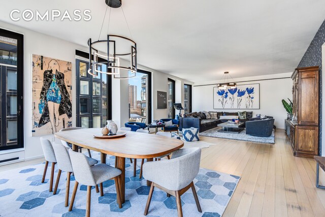 505 W 19th St Unit 7W, New York City, NY 10011 - dining space with light wood-style floors and an inviting chandelier