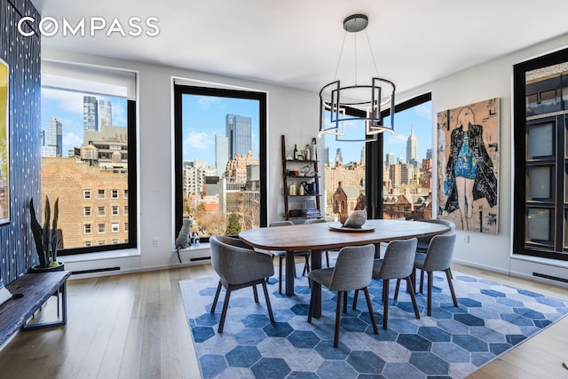 dining area featuring a wealth of natural light, a view of city, a notable chandelier, and hardwood / wood-style floors