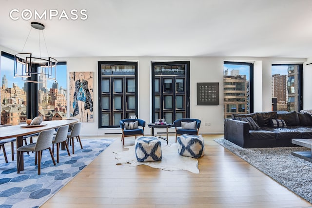 living room featuring a chandelier, a view of city, and wood finished floors