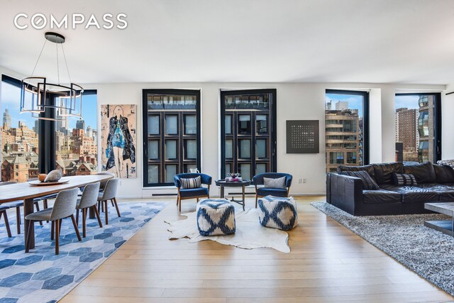 505 W 19th St Unit 7W, New York City, NY 10011 - living room featuring a view of city, wood finished floors, and a chandelier