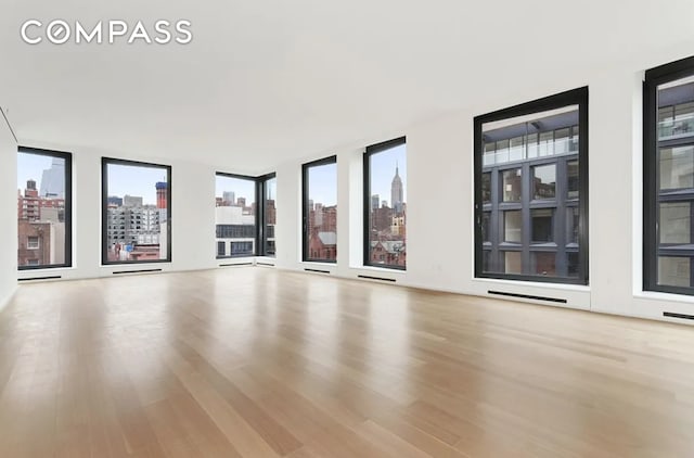 unfurnished living room with a city view and wood finished floors