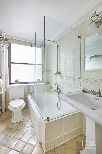 bathroom featuring tile walls, toilet, and tiled shower / bath