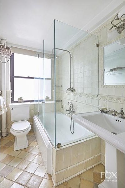 full bath featuring tile walls, tile patterned flooring, toilet, and tiled shower / bath combo