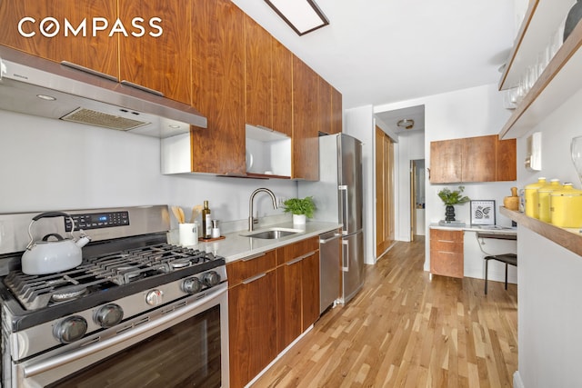 kitchen with under cabinet range hood, brown cabinets, stainless steel appliances, and a sink