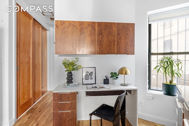 office space featuring baseboards and light wood-style floors