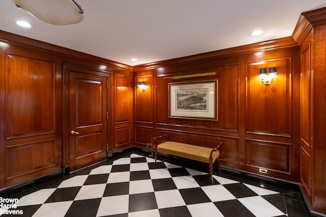 corridor with wooden walls, recessed lighting, a decorative wall, and dark floors