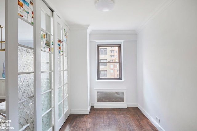 doorway with dark wood finished floors, crown molding, and baseboards