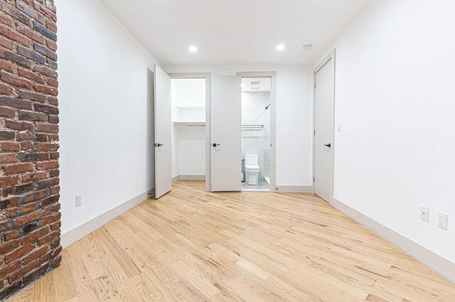282 E 38th St, New York City, NY 11203 - unfurnished bedroom with wood finished floors, a spacious closet, ensuite bath, recessed lighting, and a closet