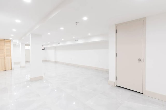 empty room with recessed lighting, baseboards, and marble finish floor