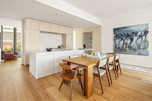 dining space featuring a wall of windows and light wood-style flooring