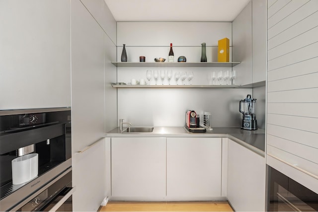 bar with stainless steel double oven, bar, and a sink