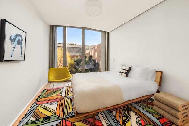 bedroom featuring a wall of windows and baseboards