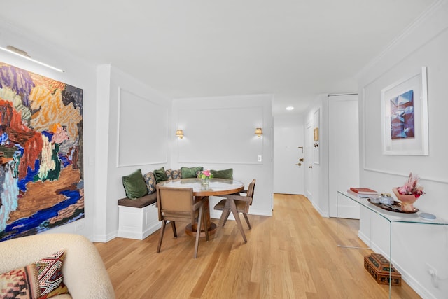 dining space with ornamental molding, baseboards, light wood finished floors, and breakfast area