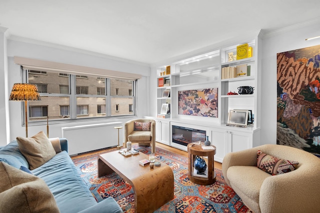 living area featuring a glass covered fireplace, radiator, wood finished floors, and ornamental molding