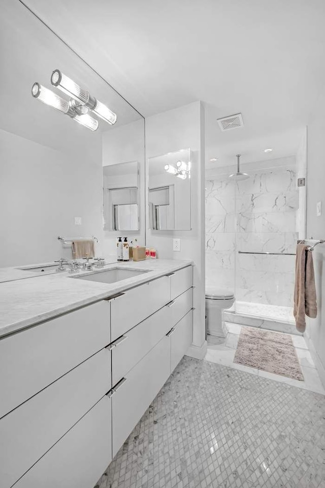 full bath featuring vanity, toilet, visible vents, and a marble finish shower