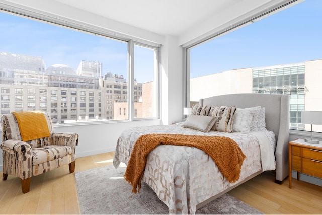 bedroom featuring a view of city and wood finished floors