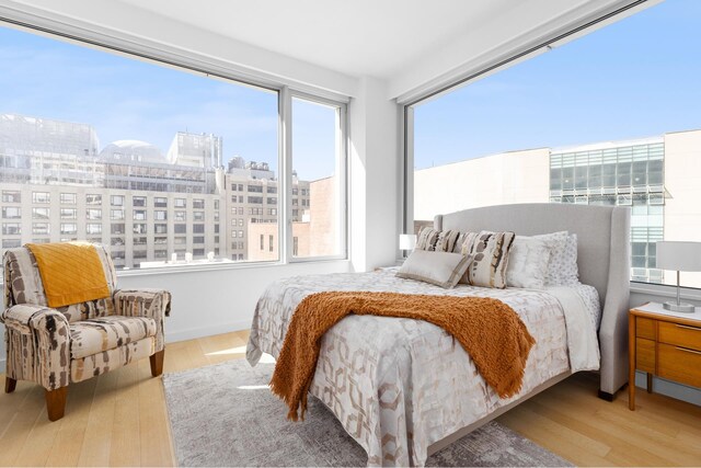 611 W 56th St Unit 7E, New York City, NY 10019 - bedroom featuring a view of city and wood finished floors