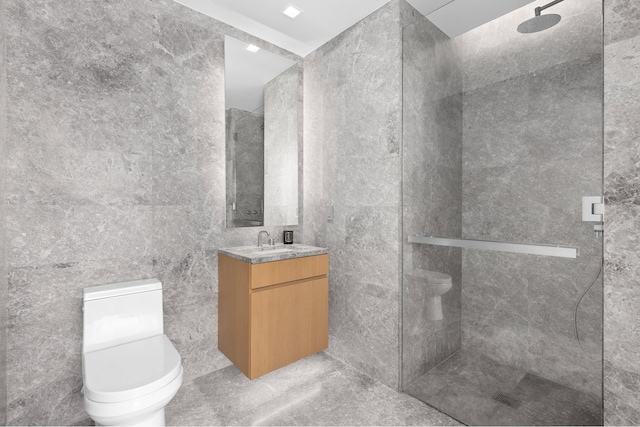 bathroom featuring vanity, tile walls, walk in shower, and toilet
