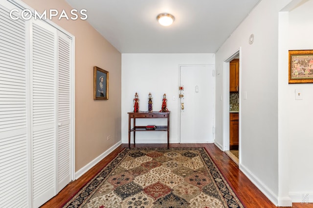 hall with baseboards and dark wood-style flooring