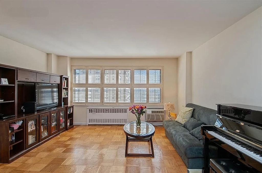 185 W End Ave Unit 12G, New York City, NY 10023 - living room with radiator heating unit, plenty of natural light, and a wall unit AC