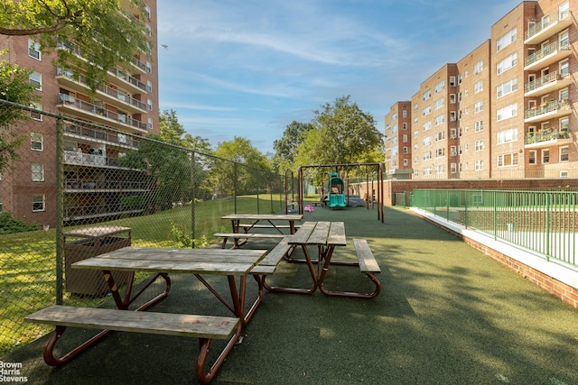 view of home's community with playground community and fence