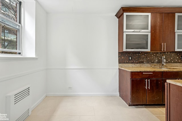 bar featuring a sink, baseboards, and backsplash