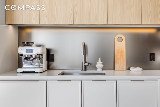 interior space with a sink, light brown cabinets, and light countertops