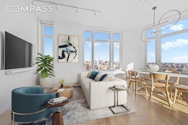 living room with track lighting, a view of city, and plenty of natural light