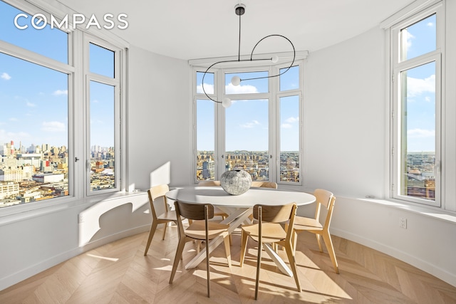 dining area featuring baseboards and a city view