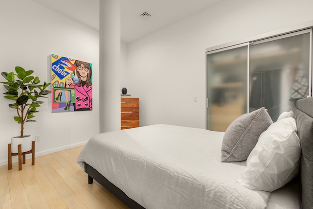 bedroom with visible vents, light wood-type flooring, and baseboards