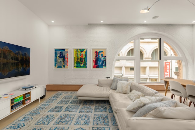 living area featuring recessed lighting and brick wall