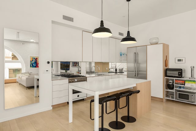 kitchen featuring white cabinets, light wood-style floors, visible vents, and appliances with stainless steel finishes