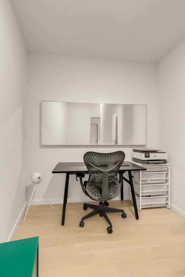 home office with baseboards and wood finished floors