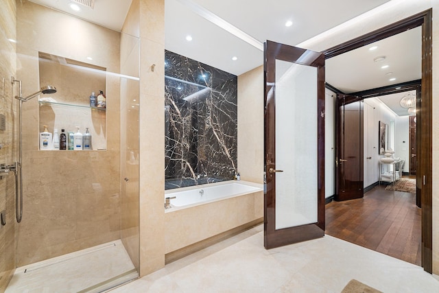 53 W 53rd St Unit 20C, New York City, NY 10019 - bathroom with a bath, a walk in shower, and recessed lighting