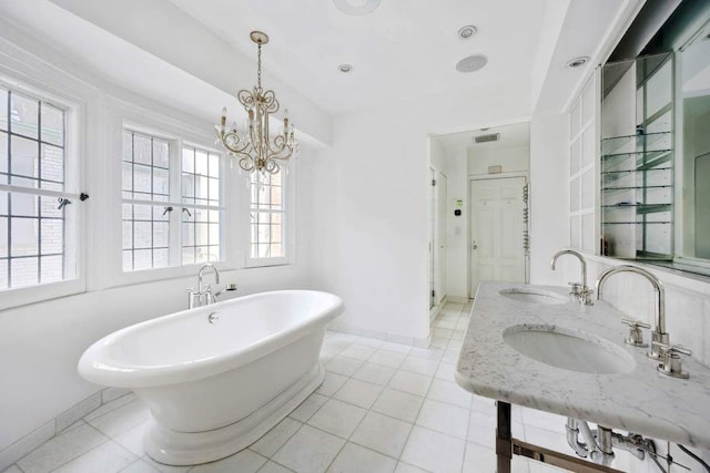 123 E 69th St, New York City, NY 10021 - full bath with a freestanding bath, tile patterned floors, baseboards, and a chandelier