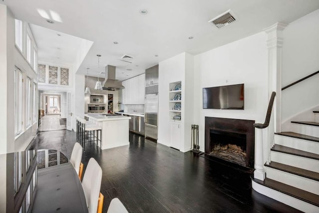 123 E 69th St, New York City, NY 10021 - living area featuring a fireplace, dark wood-style floors, stairs, and built in shelves