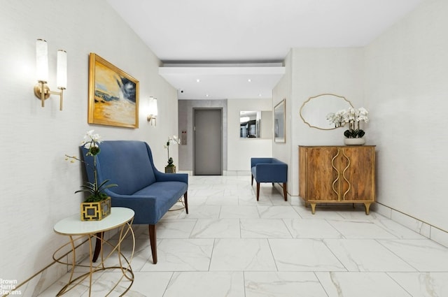 sitting room featuring marble finish floor and baseboards