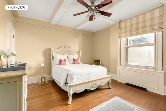 bedroom with wood finished floors, visible vents, baseboards, crown molding, and beamed ceiling