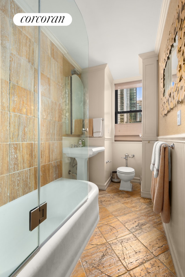 bathroom with stone tile flooring, toilet, and ornamental molding