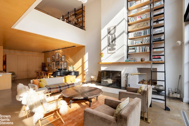 living area featuring concrete floors and a high ceiling