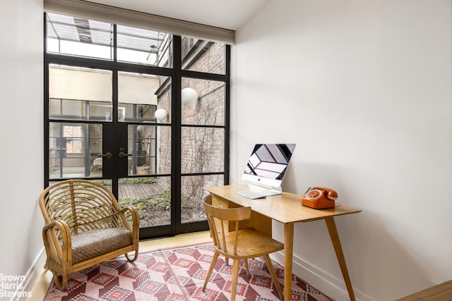 office featuring a wall of windows, french doors, plenty of natural light, and baseboards