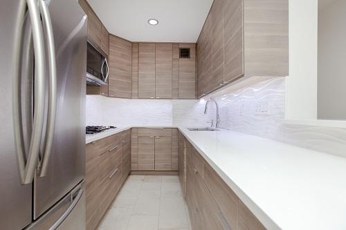 kitchen with stainless steel appliances, modern cabinets, light countertops, and a sink