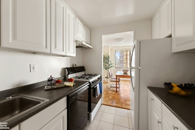 kitchen with dark countertops, under cabinet range hood, black dishwasher, range with gas stovetop, and white cabinetry