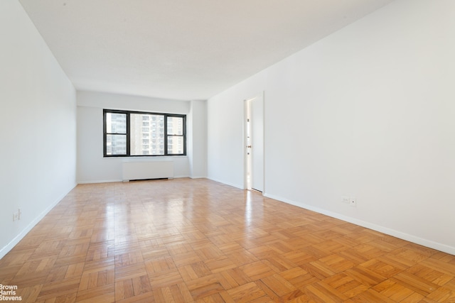 empty room with baseboards and radiator heating unit