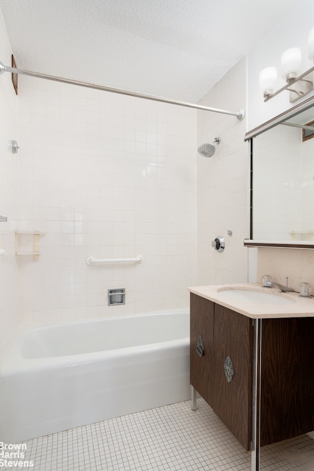 full bathroom featuring tile patterned flooring, bathing tub / shower combination, vanity, and a textured ceiling