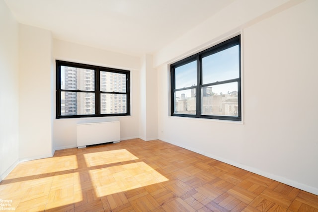 spare room featuring radiator heating unit and baseboards