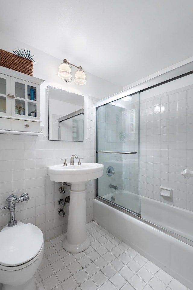 bathroom featuring toilet, tile walls, tile patterned flooring, and enclosed tub / shower combo