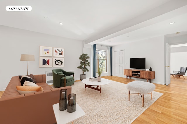 living room featuring light wood finished floors, baseboards, recessed lighting, and radiator