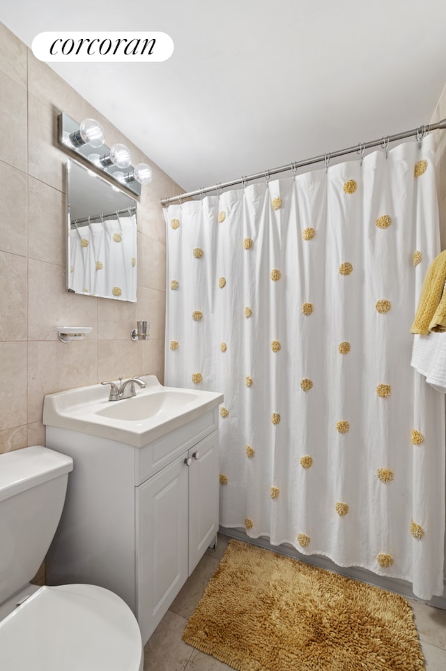 full bath with tile patterned floors, toilet, vanity, and tile walls